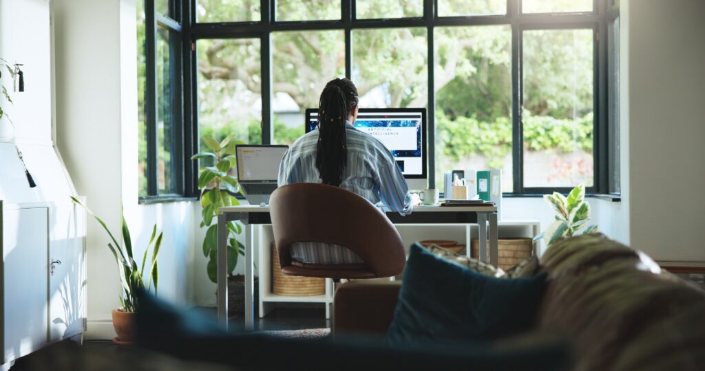 Woman working at computer at desk in living room